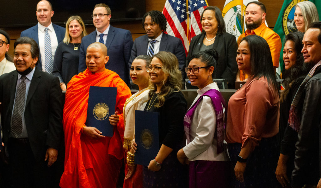 A group photo with community members from the Tacoma temple, KHAAG, KLACA and the Tacoma City Council holding the newly establish proclamation.